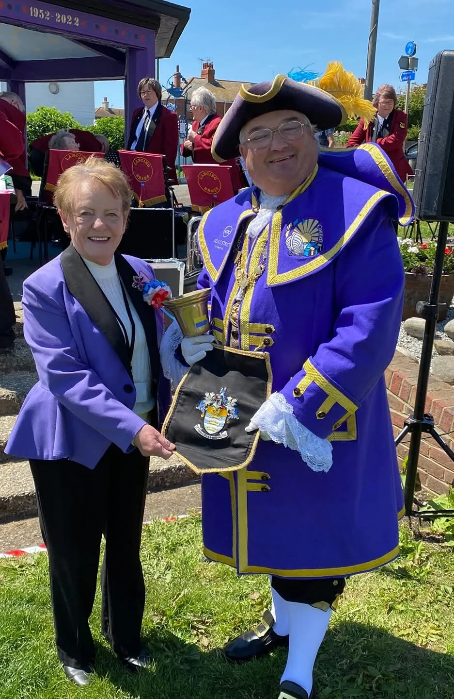 Bob Smytherman in his purple Adur robes with a Lancing councillor, a brass band playing behind them.